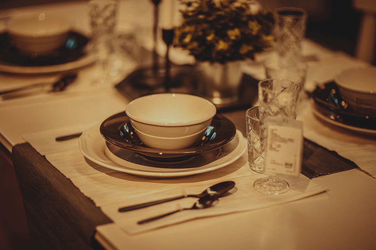 A stylish table setting with plates, cutlery, and a floral centerpiece in a cozy ambiance.